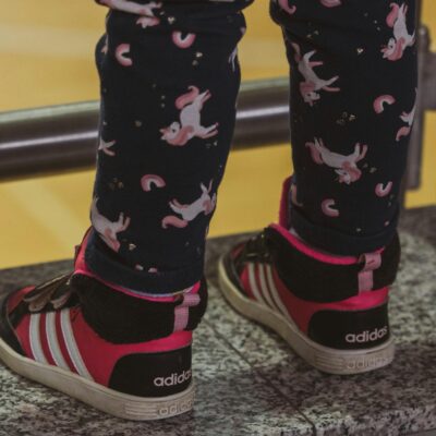 Adorable child's feet in unicorn leggings and sneakers, showcasing playful fashion for kids.