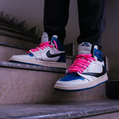 Fashion-forward sneakers with bold pink laces spotted on stairs, perfect for urban style inspiration.